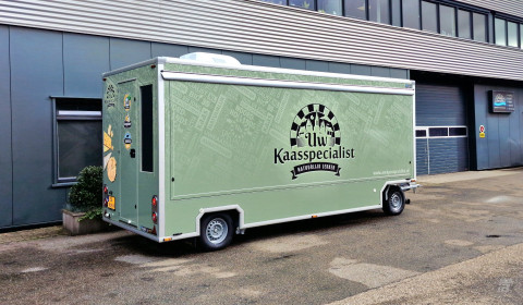 Zijaanzicht van een aanhangwagen voor kaas met gesloten luifel