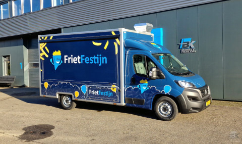 Zijaanzicht van een verkoopwagen voor patat met gesloten luifel