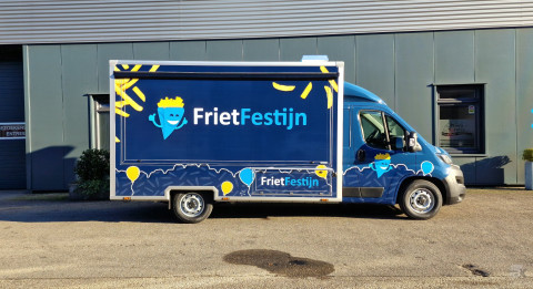 Zijaanzicht van een verkoopwagen voor patat met gesloten luifel