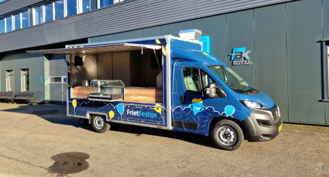 Zijaanzicht van een verkoopwagen voor patat met geopende luifel