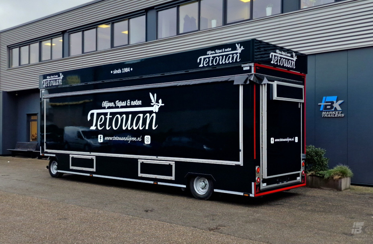 Zijaanzicht van een aanhangwagen voor olijven, tapas en noten met gesloten luifel