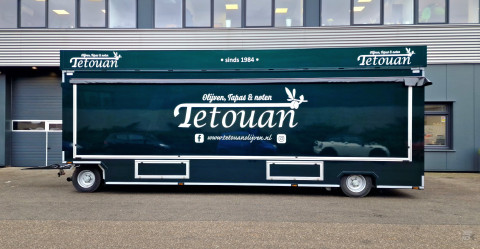 Zijaanzicht van een aanhangwagen voor olijven, tapas en noten met gesloten luifel