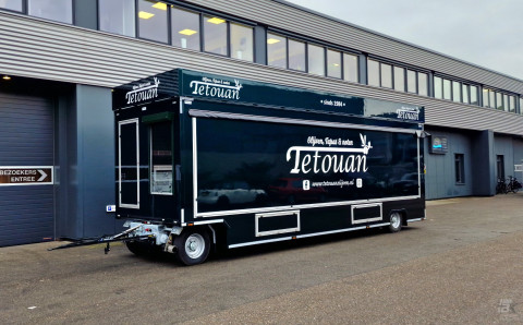 Zijaanzicht van een aanhangwagen voor olijven, tapas en noten met gesloten luifel