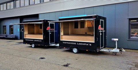 Zijaanzicht van twee kleine aanhangwagens voor loempia's met geopende luifels