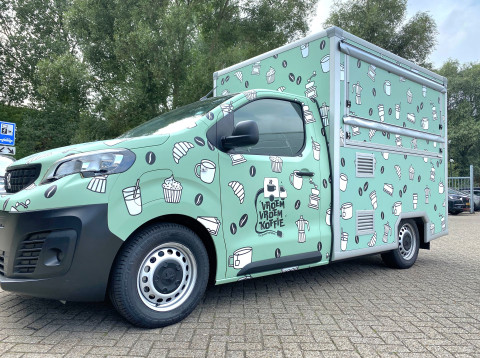 Zijaanzicht van een verkoopwagen voor loempia's met gesloten luifel