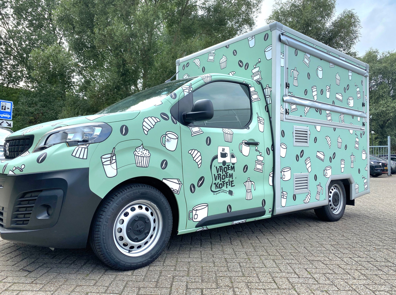 Zijaanzicht van een verkoopwagen voor loempia's met gesloten luifel