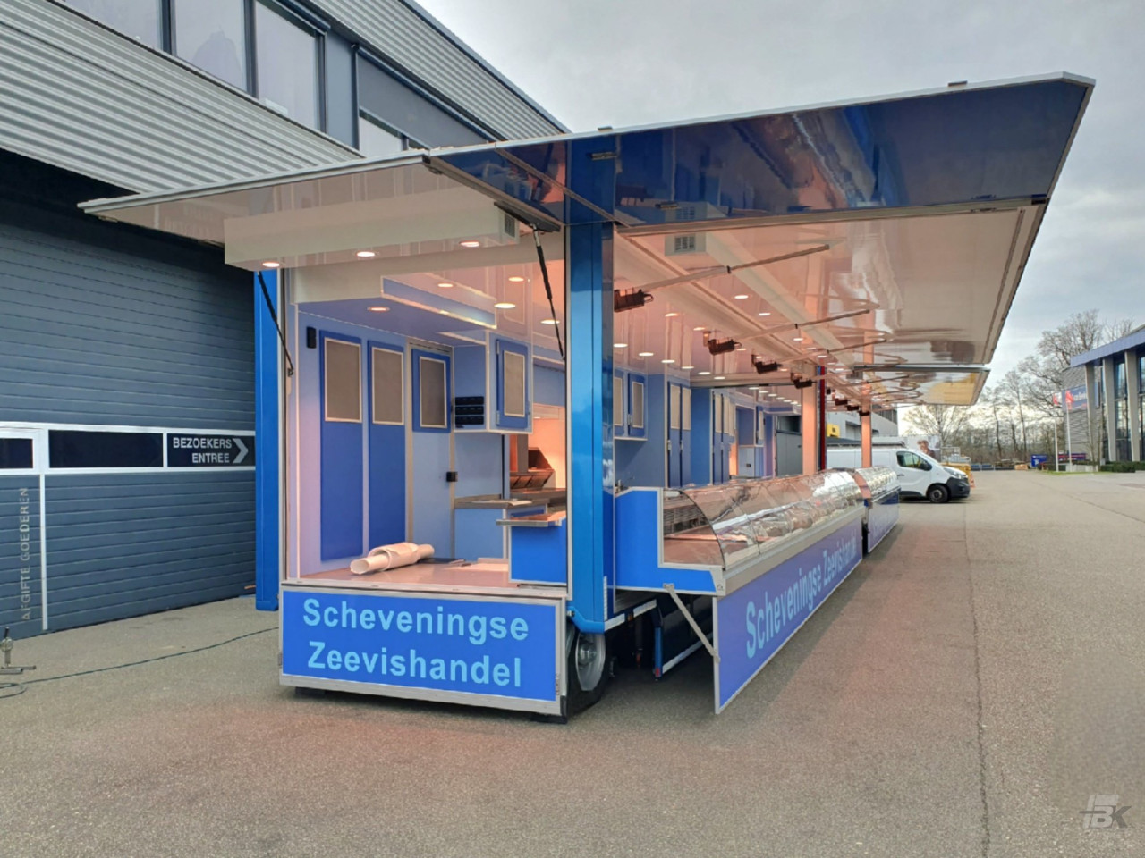 Zijaanzicht van twee verkoopwagens voor vis met geopende luifels