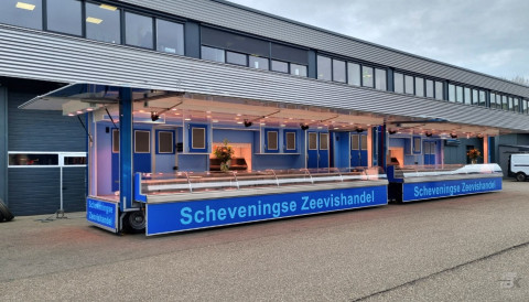 Zijaanzicht van twee verkoopwagens voor vis met geopende luifels