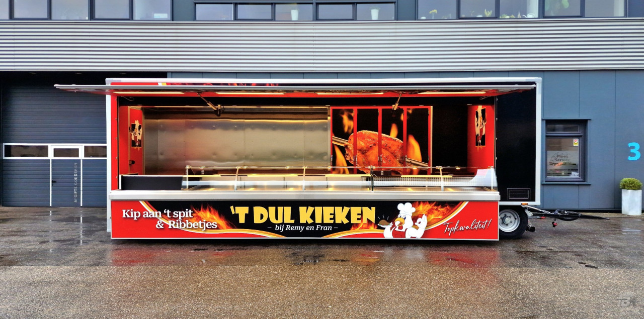Zijaanzicht van een aanhangwagen voor kip aan het spit met geopende luifel