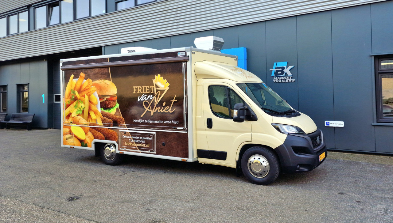 Zijaanzicht van een verkoopwagen voor patat met gesloten luifel