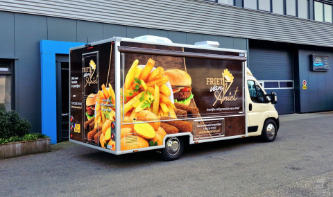 Zijaanzicht van een verkoopwagen voor patat met gesloten luifel