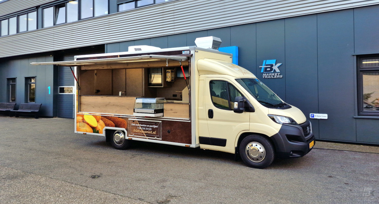 Zijaanzicht van een verkoopwagen voor patat met geopende luifel