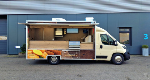 Zijaanzicht van een verkoopwagen voor patat met geopende luifel