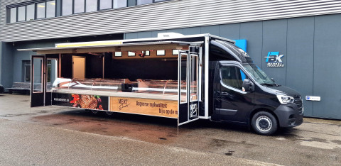 Zijaanzicht van een verkoopwagen voor vlees met geopende luifel en zijborden