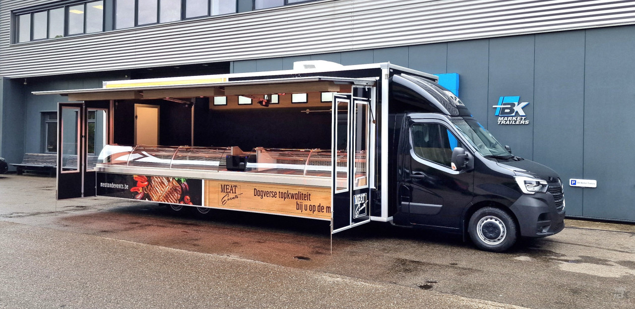Zijaanzicht van een verkoopwagen voor vlees met geopende luifel en zijborden
