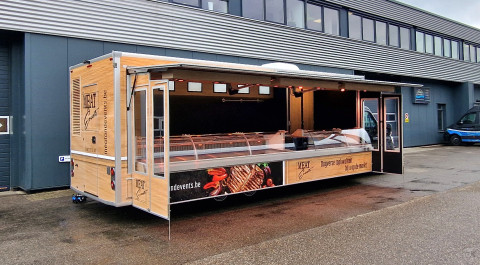Zijaanzicht van een verkoopwagen voor vlees met geopende luifel en zijborden