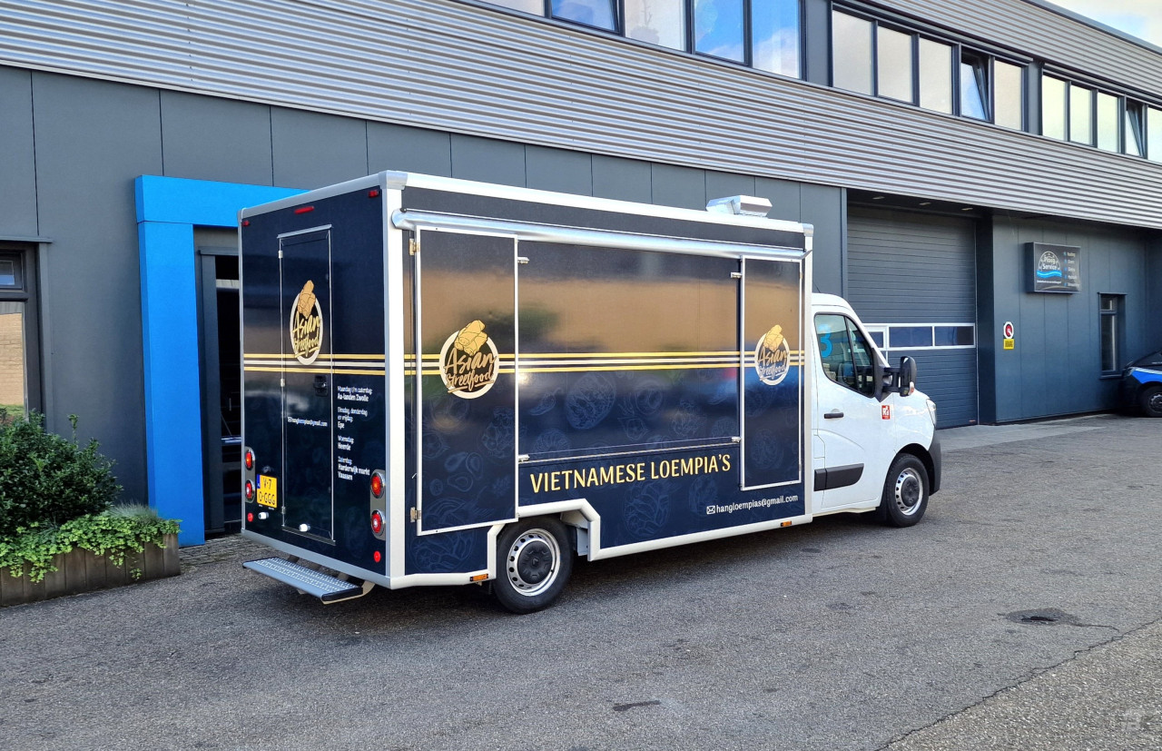 Zijaanzicht van een verkoopwagen voor loempia's met gesloten luifel