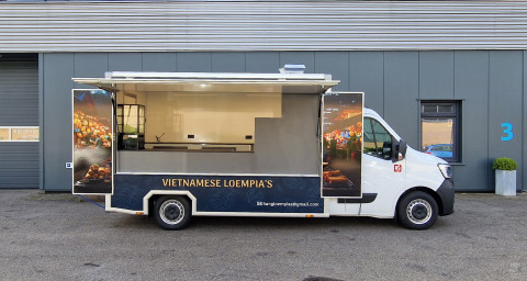 Zijaanzicht van een verkoopwagen voor loempia's met geopende luifel