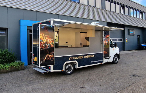 Zijaanzicht van een verkoopwagen voor loempia's met geopende luifel