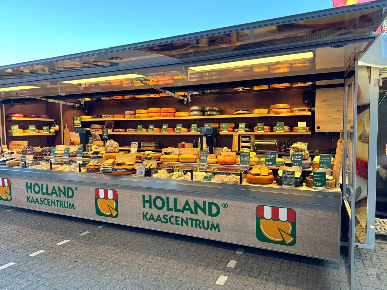 Volledig uitgestalde aanhangwagen voor kaas, op een parkeerterrein