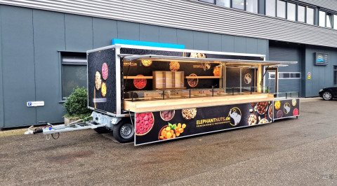 Zijaanzicht van een aanhangwagen voor noten met geopende luifel