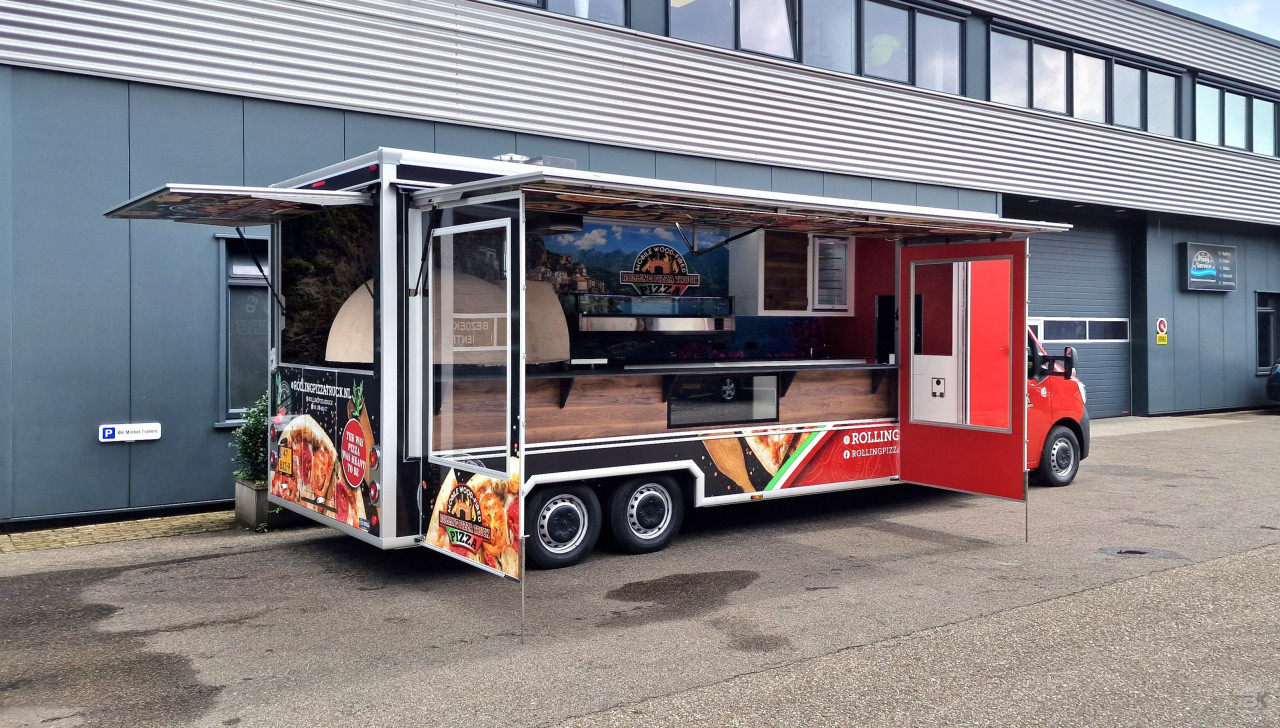 Zijaanzicht van een verkoopwagen voor pizza met geopende luifel