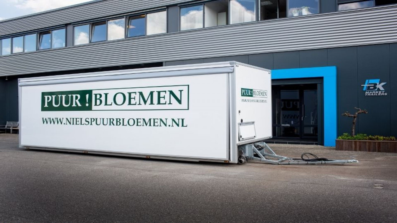 Zijaanzicht van een aanhangwagen voor bloemen met gesloten luifel