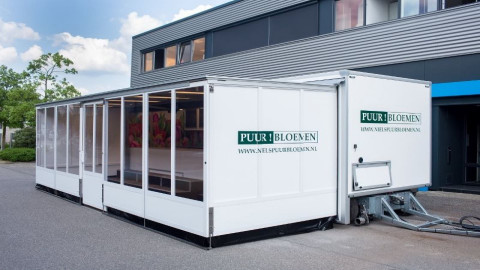 Zijaanzicht van een aanhangwagen voor bloemen met geopende luifel