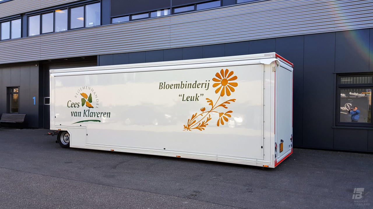 Zijaanzicht van een aanhangwagen voor bloemen met gesloten luifel