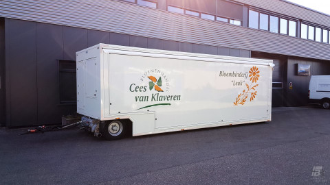 Zijaanzicht van een aanhangwagen voor bloemen met gesloten luifel