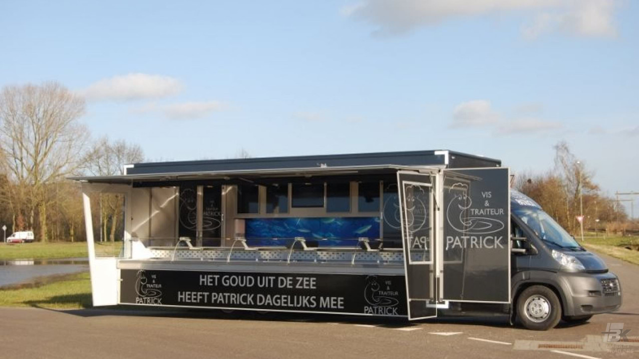 Zijaanzicht van een verkoopwagen voor vis met geopende luifel en zijborden