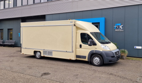 Zijaanzicht van een verkoopwagen voor diverse branches met gesloten luifel