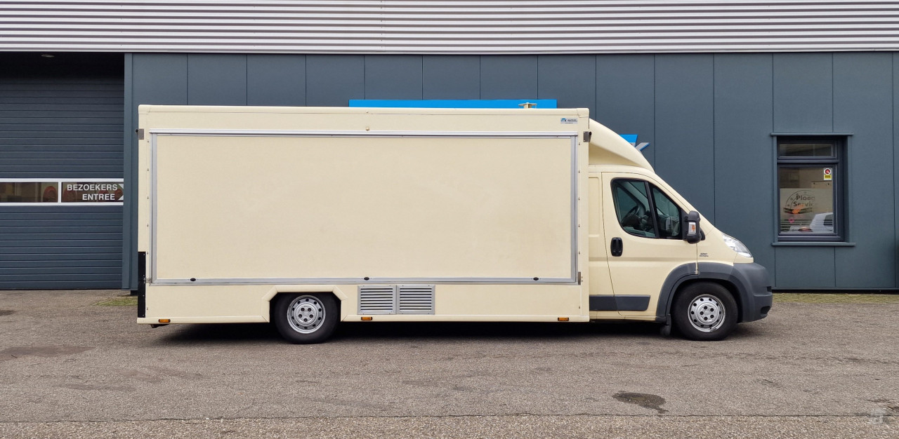 Zijaanzicht van een verkoopwagen voor diverse branches met gesloten luifel