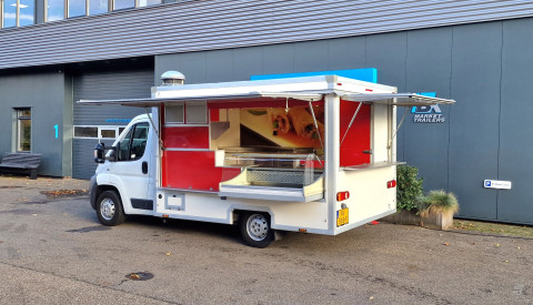 Zijaanzicht van een verkoopwagen voor diverse branches met geopende luifel