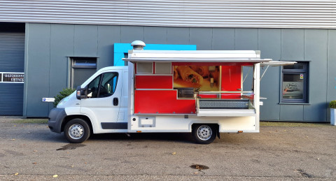 Zijaanzicht van een verkoopwagen voor diverse branches met geopende luifel