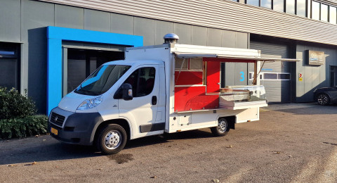 Zijaanzicht van een verkoopwagen voor diverse branches met geopende luifel