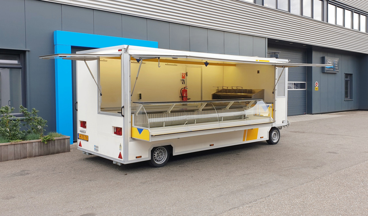 Zijaanzicht van een aanhangwagen voor diverse branches met geopende luifel