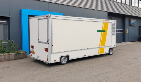 Zijaanzicht van een aanhangwagen voor diverse branches met gesloten luifel