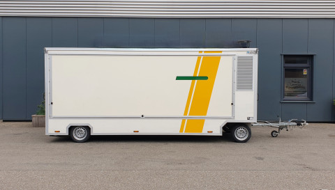 Zijaanzicht van een aanhangwagen voor diverse branches met gesloten luifel