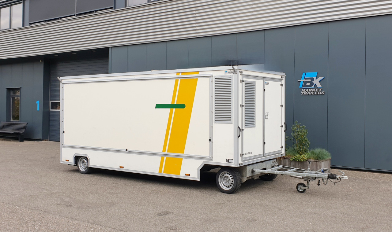 Zijaanzicht van een aanhangwagen voor diverse branches met gesloten luifel