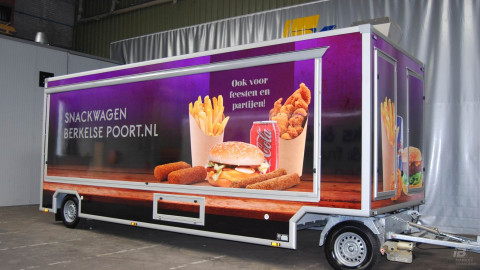 Zijaanzicht van een aanhangwagen voor patat en snacks met gesloten luifel