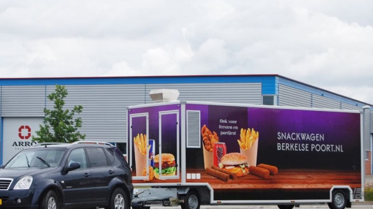 Zijaanzicht van een aanhangwagen voor patat en snacks met gesloten luifel