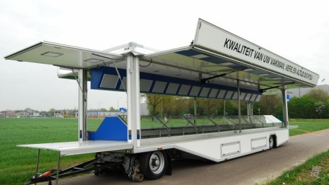 Zijaanzicht van een aanhangwagen voor kip met geopende luifel