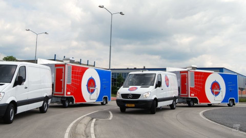 Zijaanzicht van twee Mercedes bestelwagens met aanhangwagens voor vis met gesloten luifels