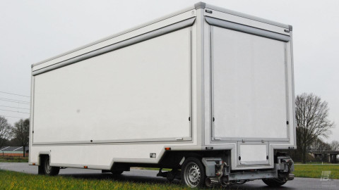 Zijaanzicht van een aanhangwagen voor naaigerei met gesloten luifel