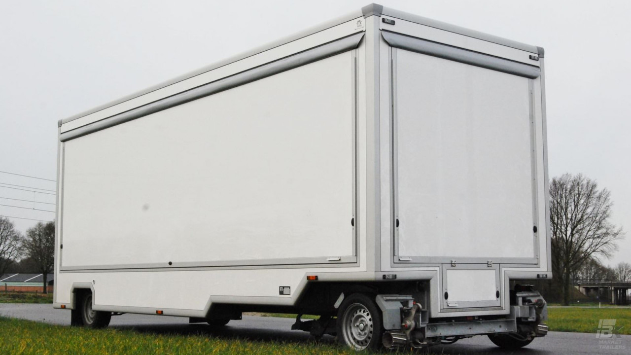 Zijaanzicht van een aanhangwagen voor naaigerei met gesloten luifel