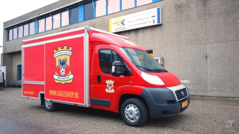 Zijaanzicht van een verkoopwagen voor promotie en merchandise met gesloten luifel