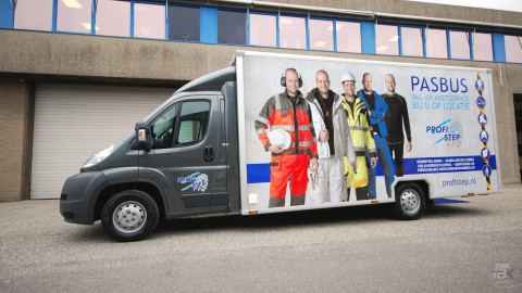 Zijaanzicht van een verkoopwagen voor bedrijfskleding met gesloten luifel