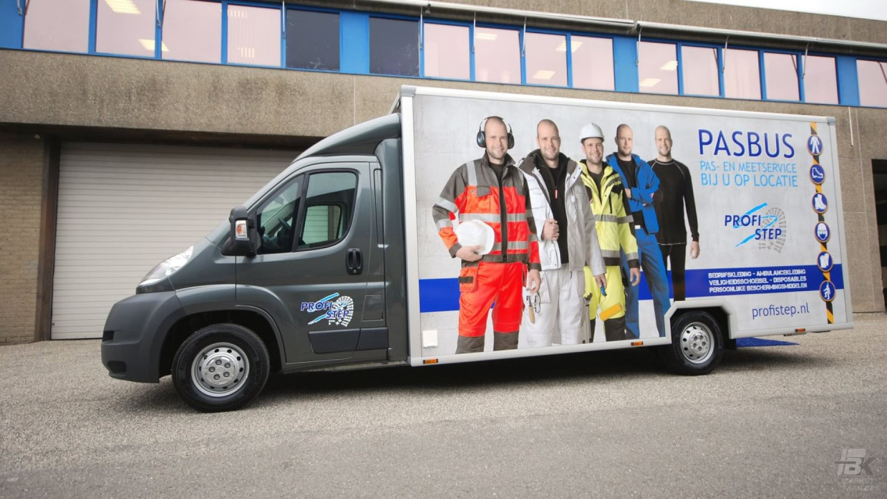 Zijaanzicht van een verkoopwagen voor bedrijfskleding met gesloten luifel