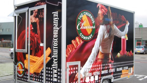 Zijaanzicht van een aanhangwagen voor churros met gesloten luifel